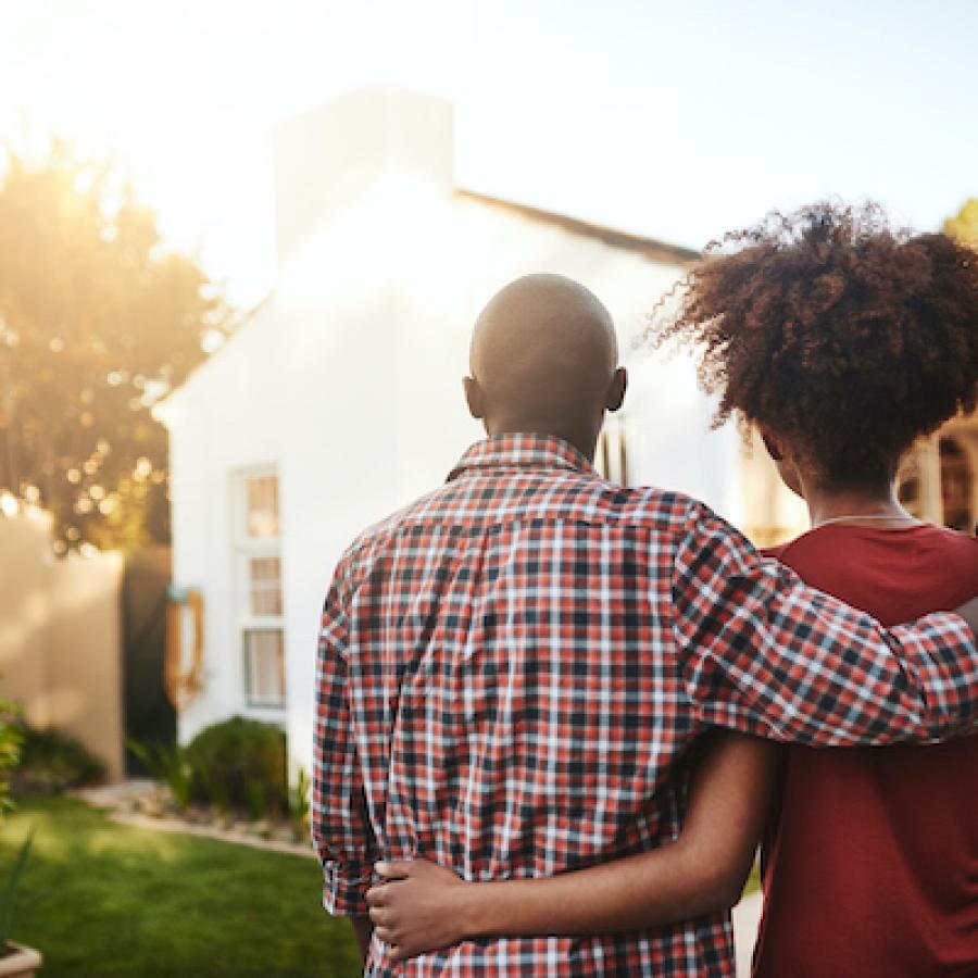 african-american-couple-standing-in-front-of-new-home
